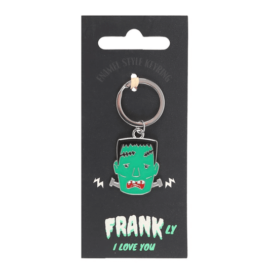 Keychain with green monster design on a black card with text