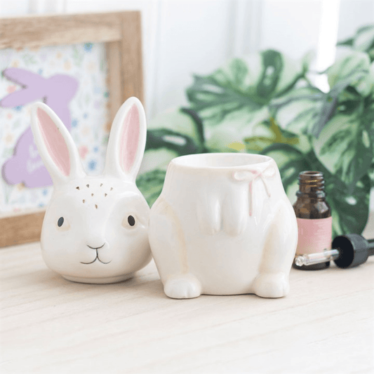 Two white ceramic rabbit-shaped planters on a surface with a blurred background