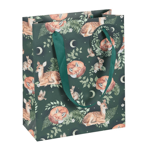Gift bag with forest-themed design featuring deer and foliage on a dark green background.