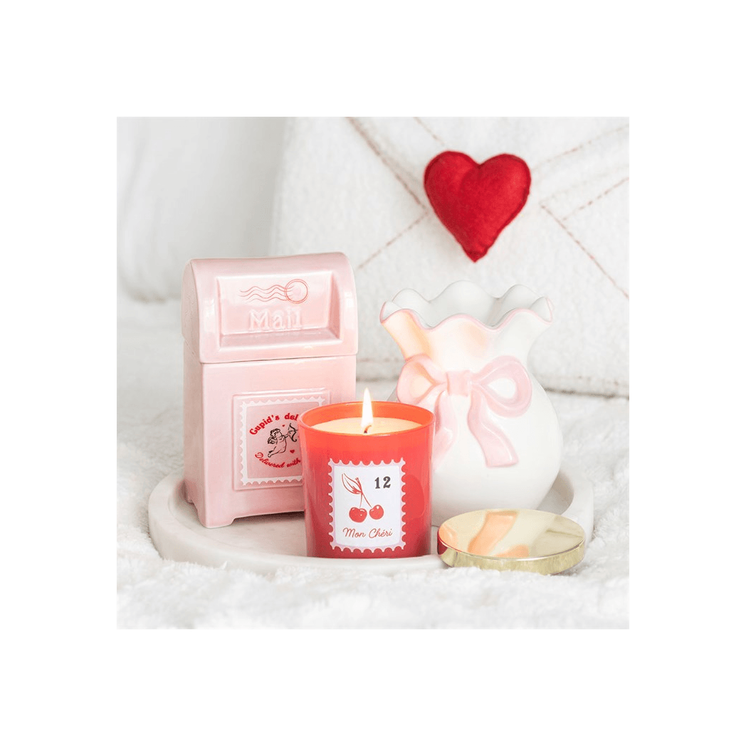 Pink Bow Oil Burner with a soft pink bow among decorative candles and a mail box, perfect for coquette style