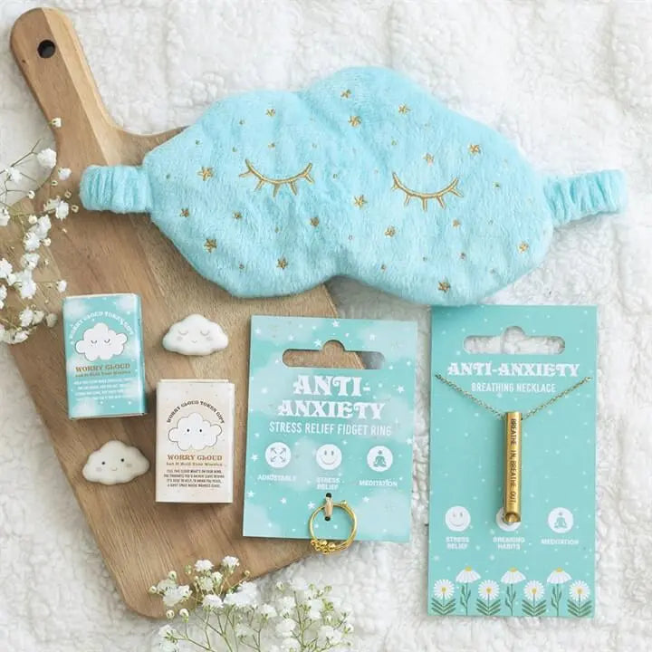 Image of Rain or Shine Anti-Anxiety Breathing Necklace with sleep mask and stress relief products on a wooden board.