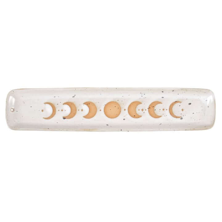 Decorative rolling pin with moon phases on a speckled surface