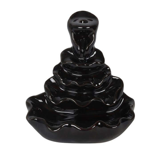 Black ceramic incense burner with wavy design on a white background