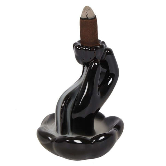 Black ceramic incense burner with a single incense stick on a white background