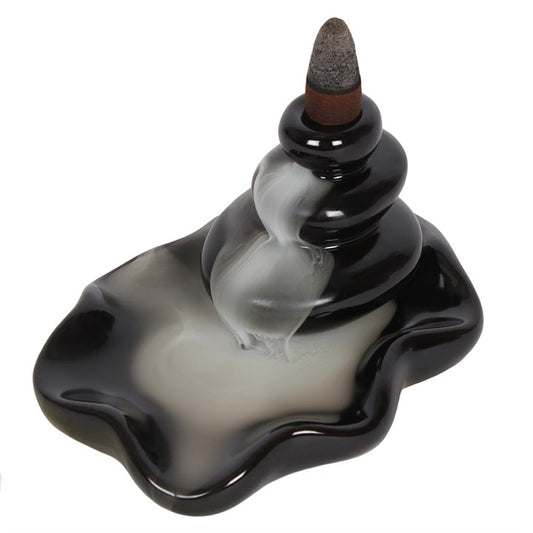 Black and gray incense burner with a cone on a white background
