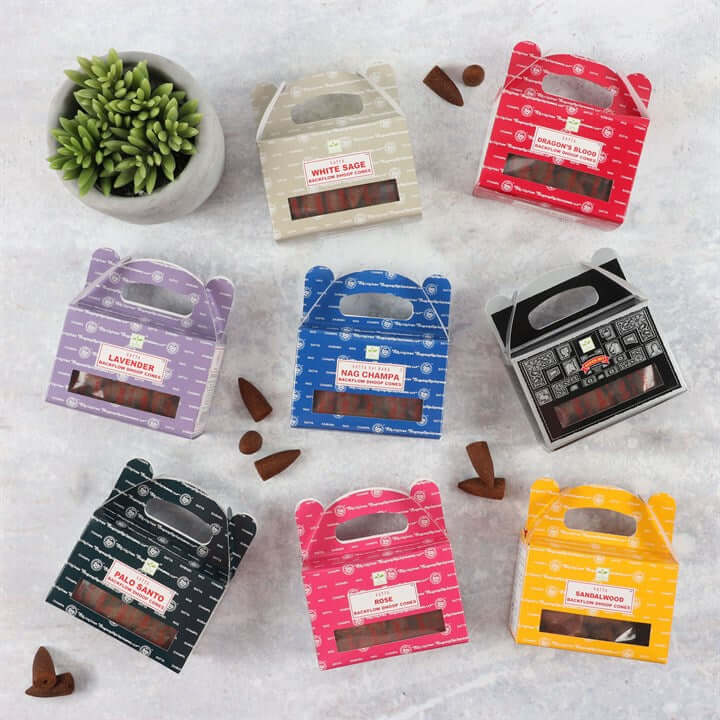 Colorful packages of incense sticks on a textured surface with a plant in the corner.