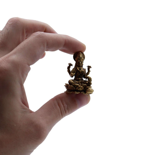 Brass Miniature Laxmi God held in hand, showcasing intricate design and craftsmanship, symbolizing prosperity.