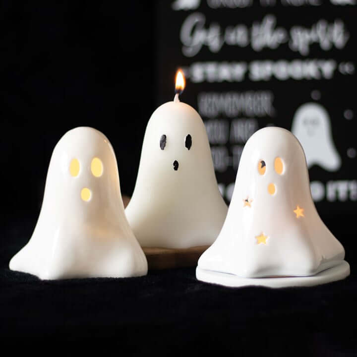 Three 10cm Unscented Ghost Candles glowing with playful expressions, perfect for Halloween decor.
