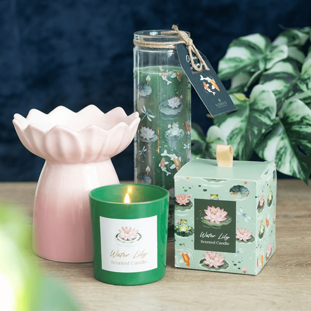 Decorative candles and diffuser with water lily design on a wooden surface.