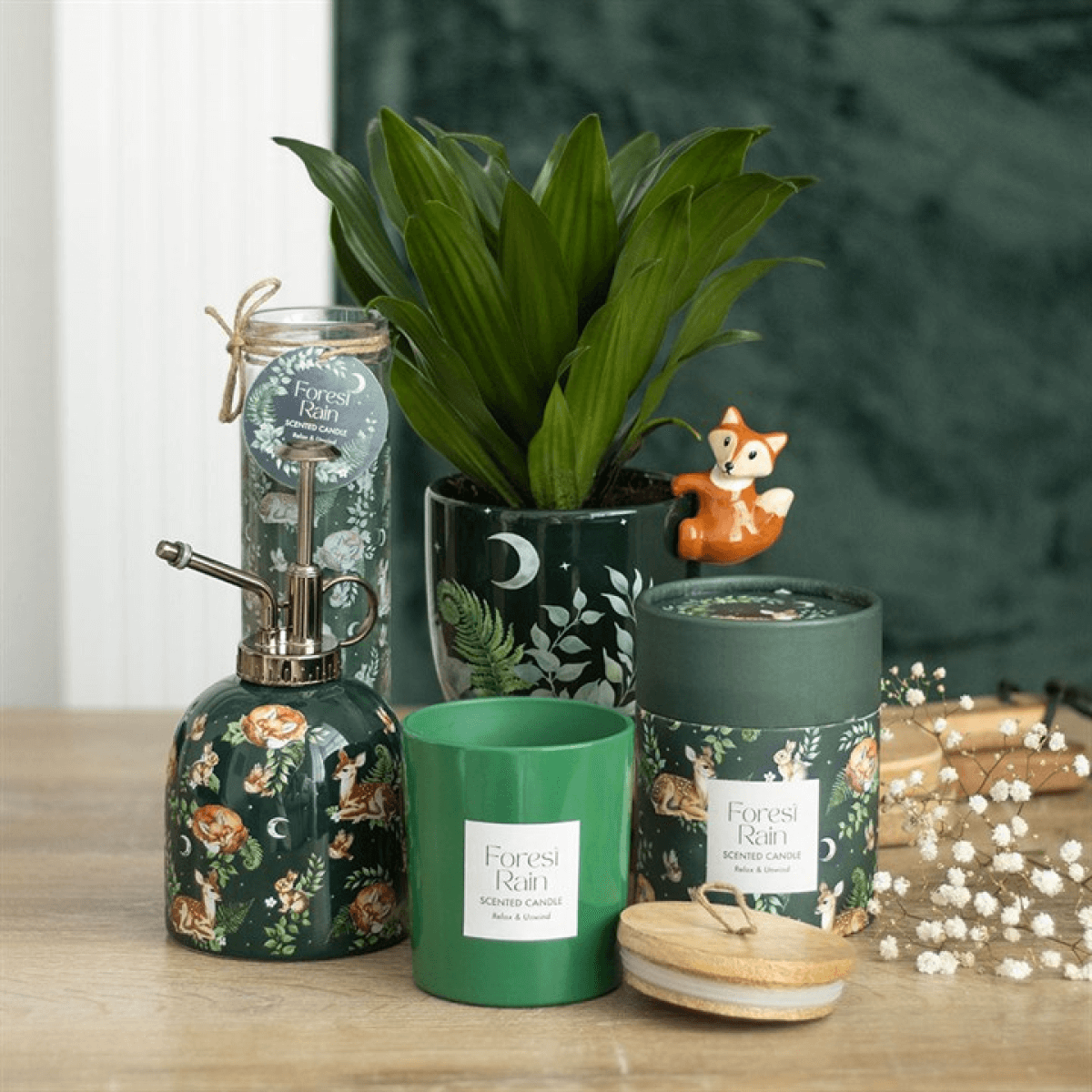 Decorative items including a plant, candle, and soap dispenser on a wooden surface with a green background.