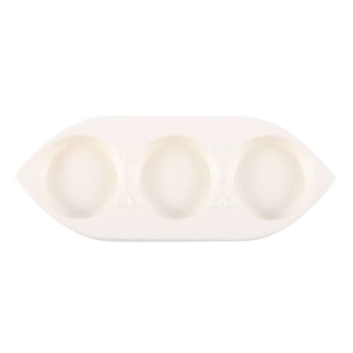 White ceramic dish with three compartments on a white background
