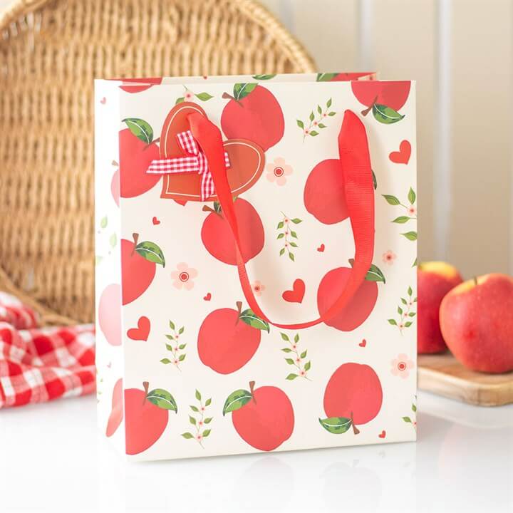 Gift bag with red apple pattern on a white background