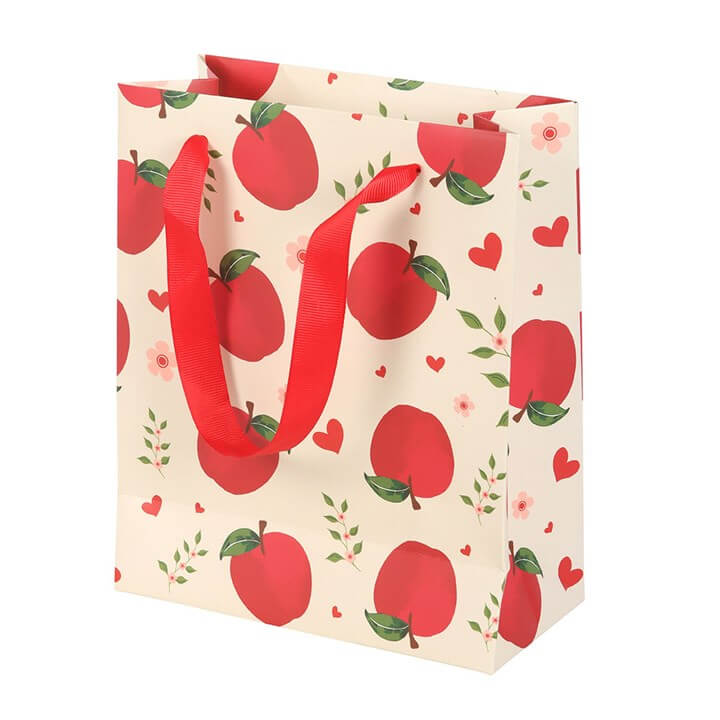 Gift bag with red apple pattern and red handles on a white background