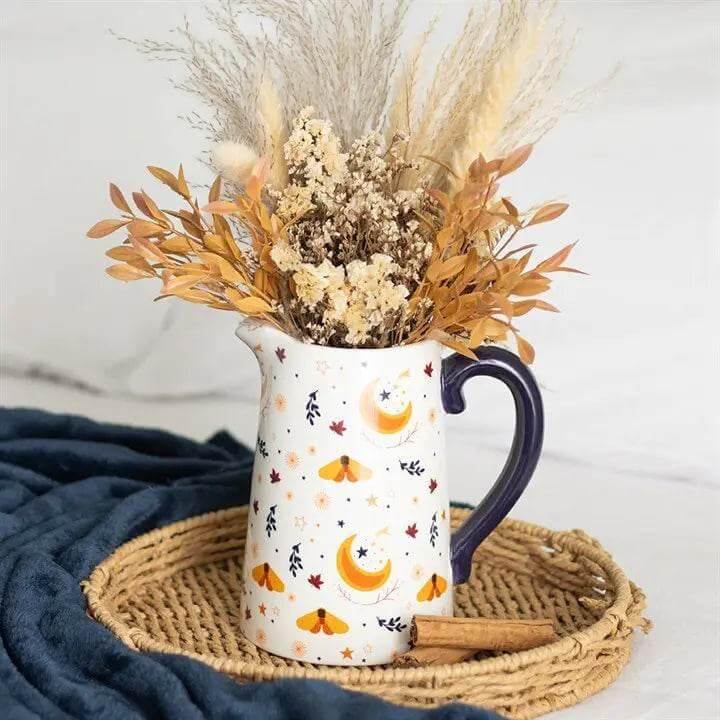 Autumn Magic Harvest Moon Print Ceramic Flower Jug filled with dried flowers on a woven tray.