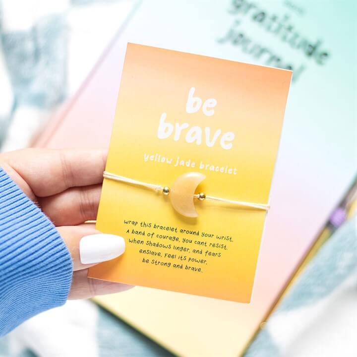 Be Brave Yellow Jade Crystal Moon Bracelet displayed on a card with inspirational text, featuring a yellow jade crescent moon charm.