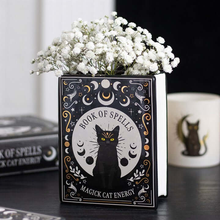 Black Cat Magick Book Shaped Flower Vase with flowers, perfect for adding charm and style to your decor.