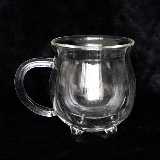 Clear double walled glass cauldron mug on a dark background, perfect for magical sipping.