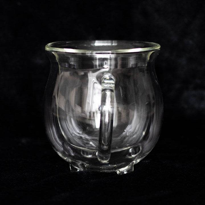 Clear double walled glass cauldron mug showcasing its unique design and handle, perfect for hot or cold beverages.