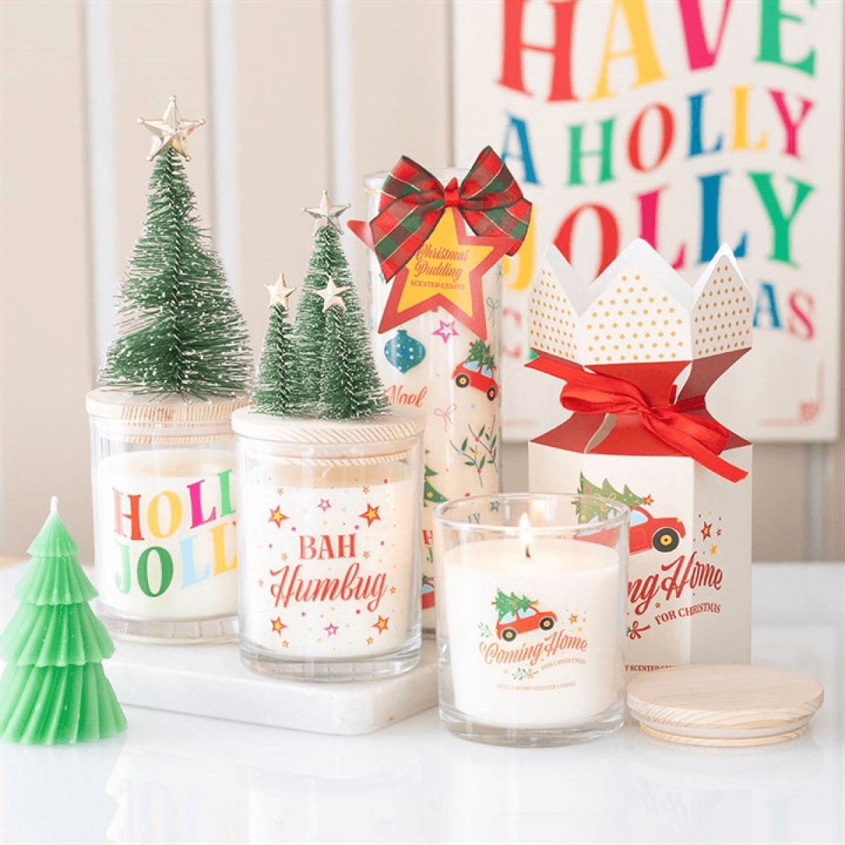 Spiced Berry Candles displayed with festive decorations including trees, vibrant packaging, and holiday-themed designs.