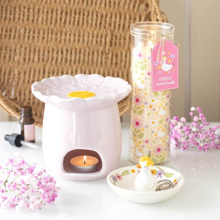 Daisy & Duck Print Vanilla Tube Candle displayed with a ceramic warmer and flower accents