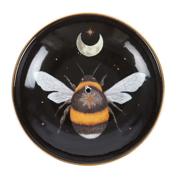 Decorative plate with a bee and moon design on a black background