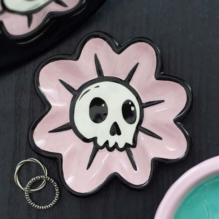 Cute, creepy, and practical—the Flower Skull Trinket Dish is the perfect blend of sweet and spooky. Featuring a delicate flower shape with a bold skull centre, this unique piece adds personality and attitude to any space. Ideal for keeping your everyday e