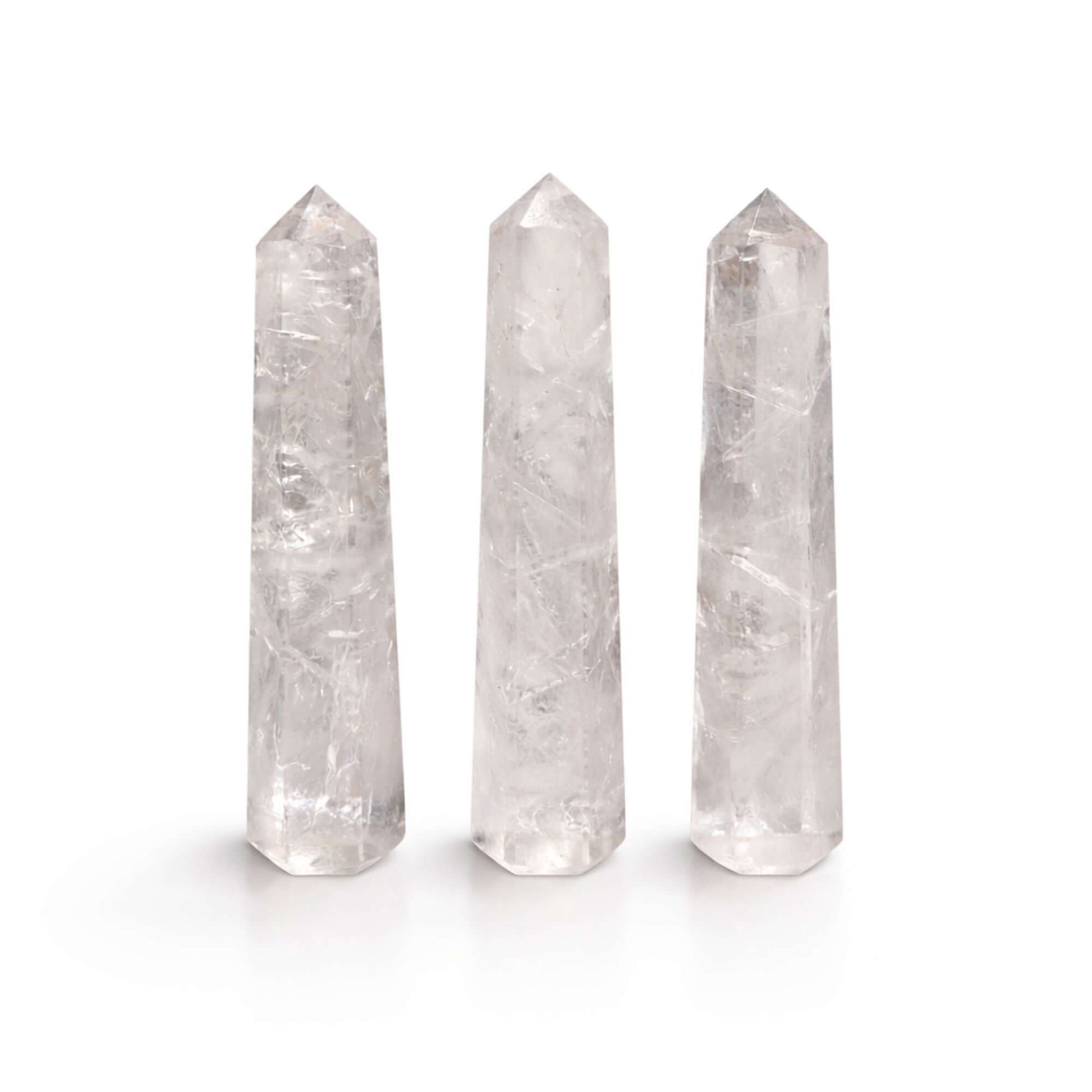 Gemstone Clear Quartz Six Face Obelisk Points arranged in a row, showcasing their polished finish and clarity.