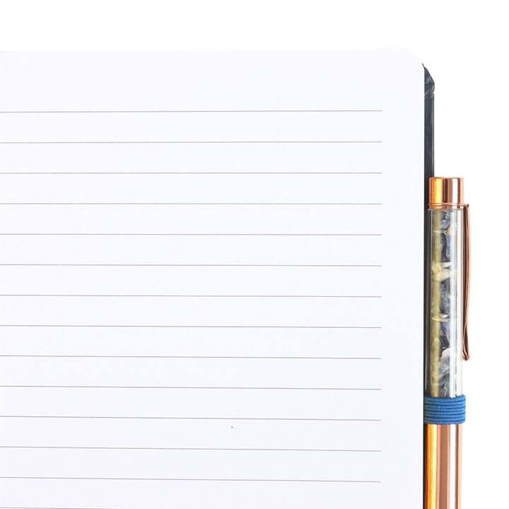 Clear pen with bronze accents on a lined notebook page