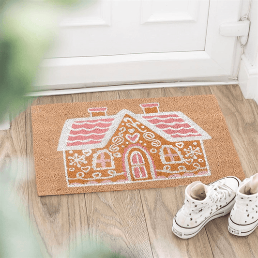 Natural Pink Gingerbread House Doormat positioned at a doorstep, perfect for holiday decor.
