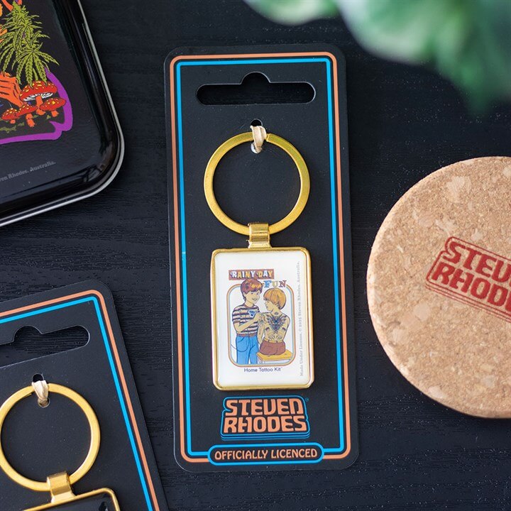 Keychain in packaging with 'Steven Rhodes' branding on a dark surface.