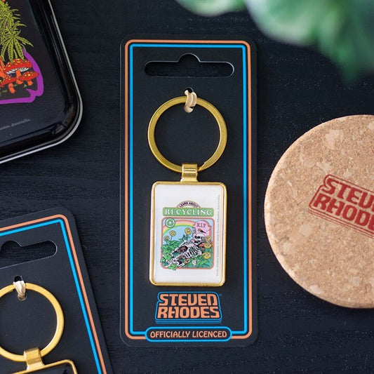 Keychain in packaging with 'Steven Rhodes' branding on a dark surface.