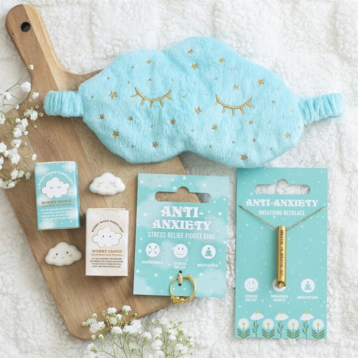 Image of Rain or Shine Anti-Anxiety Breathing Necklace with sleep mask and stress relief products on a wooden board.