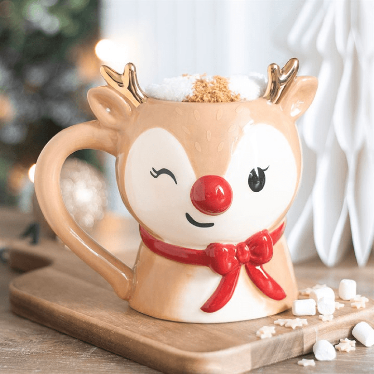 Colorful ruby reindeer mug with a winking face and marshmallows, part of a mug and socks set for winter.