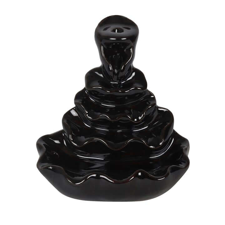 Black ceramic incense burner with wavy design on a white background