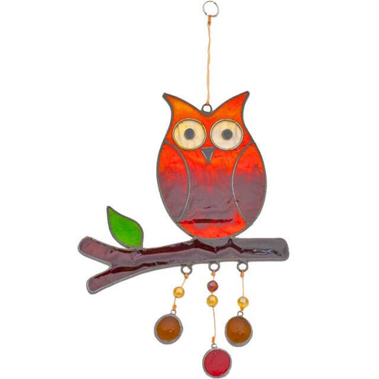 Decorative glass owl on a branch with hanging beads against a white background