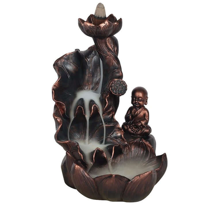 Decorative incense burner with a lotus flower and a sitting figure on a white background