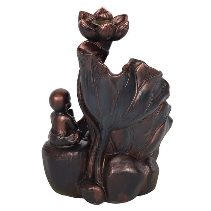 Bronze-colored decorative item with a figure sitting under a lotus flower on a white background