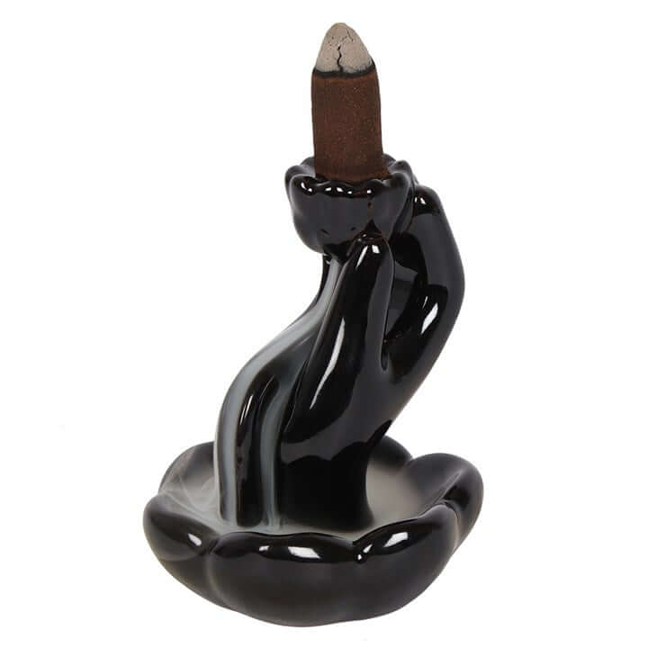 Black ceramic incense burner with a single incense stick on a white background