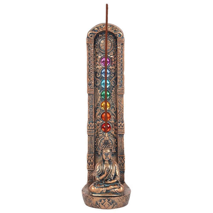 Decorative incense burner with chakra stones and Buddha figure on a white background