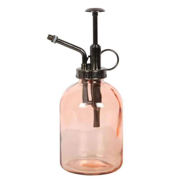 Pink glass spray bottle with black metal nozzle on a white background