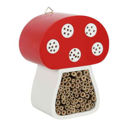 Mushroom-shaped insect hotel with red cap and white body on a white background