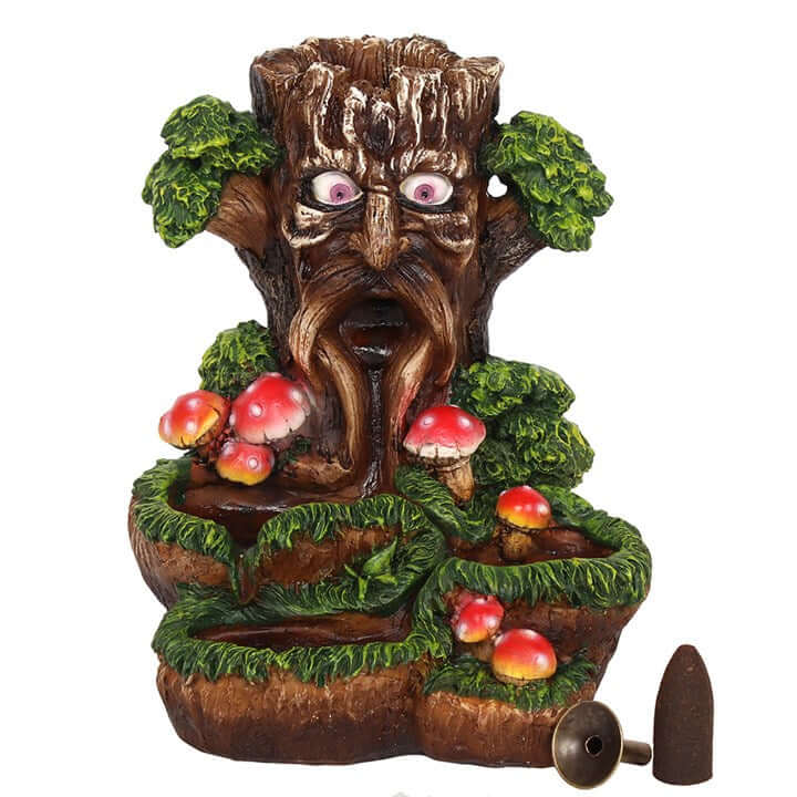 Decorative tree-like sculpture with eyes, mushrooms, and apples on a white background