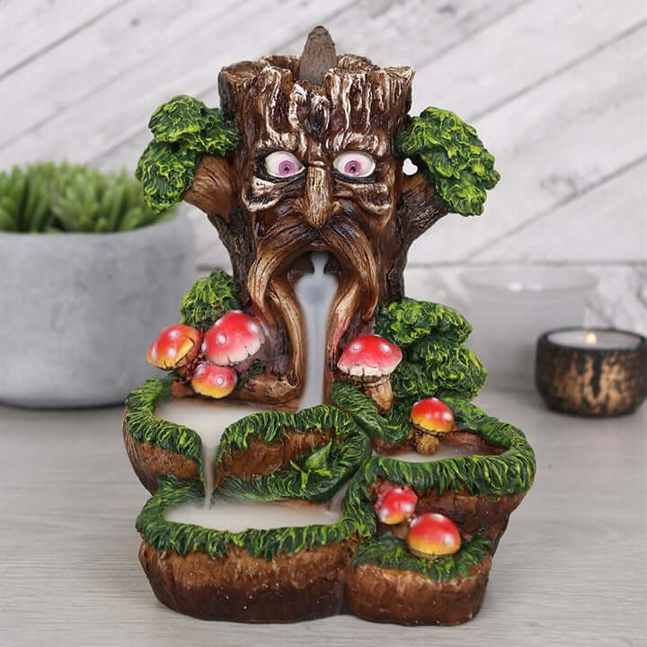 Decorative tree-like sculpture with face, mushrooms, and foliage on a neutral background