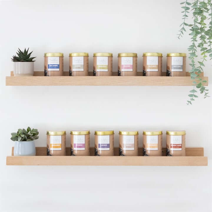 6 Tins of Elements Lemon Grass Jumbo Backflow Cones displayed on wooden shelves with decorative plants.
