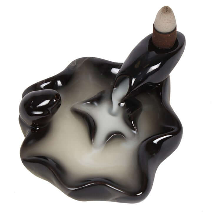 Black and white wavy incense burner with a single incense stick on a white background