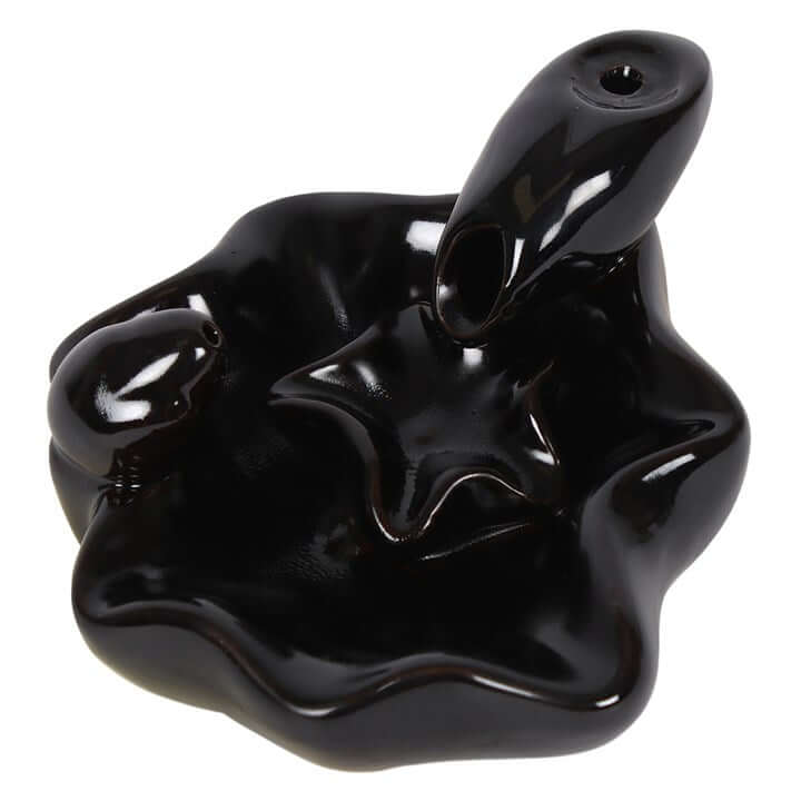 Black ceramic incense burner with wavy design on a white background