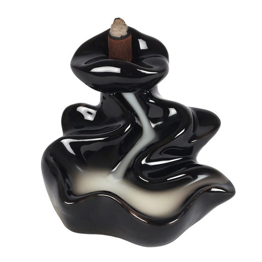 Black wavy incense burner with a single incense stick on a white background