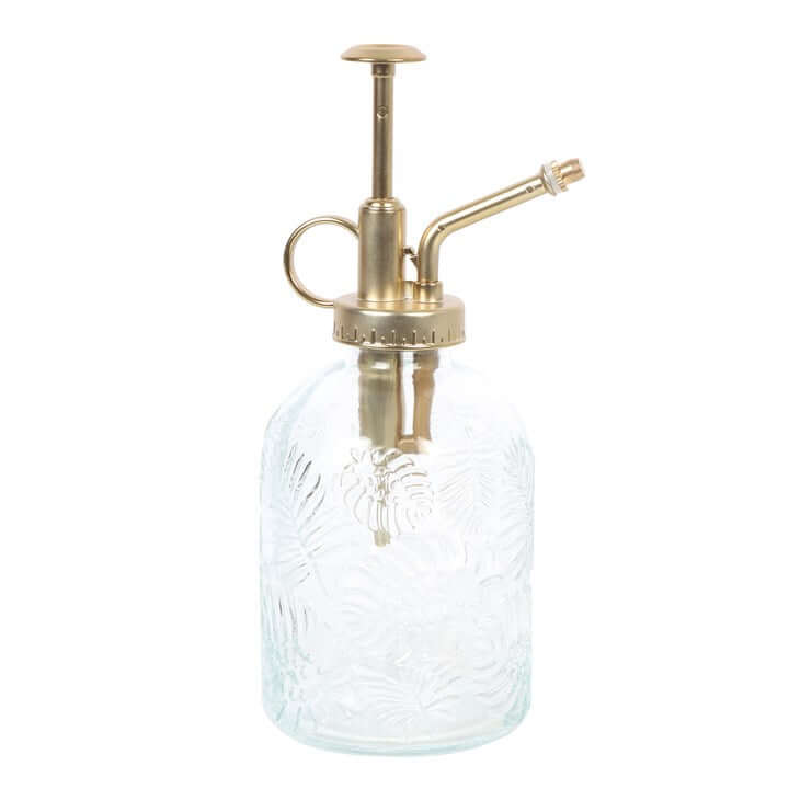 Clear glass bottle with brass pump on a white background