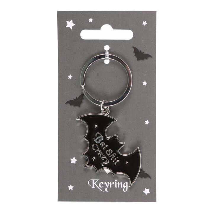 Black bat-shaped keyring on a gray card with star decorations