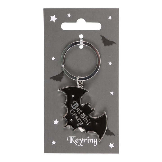 Black bat-shaped keyring on a gray card with star decorations